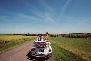 Couple just married in a convertible beetle car