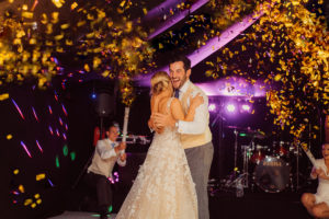 Bride & groom dancing around gold confetti