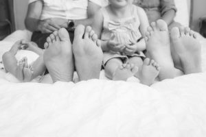 Families feet in a row on a bed