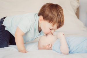 Boy kissing his baby brother