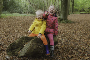 2 children giggling in a woodland