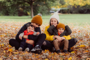 4 children sat in the Autumn leaves
