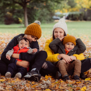 4 children sat in the Autumn leaves