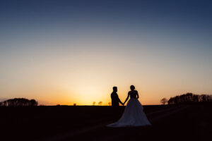 Bride & groom walking in the sunset